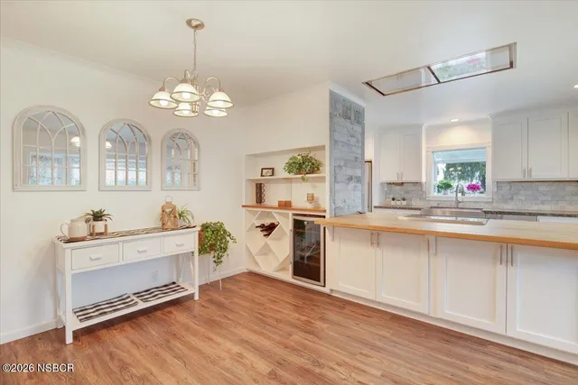 a kitchen with a refrigerator a sink cabinets and wooden floor
