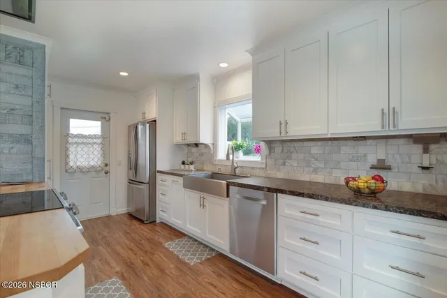a kitchen with cabinets a sink a window and stainless steel appliances