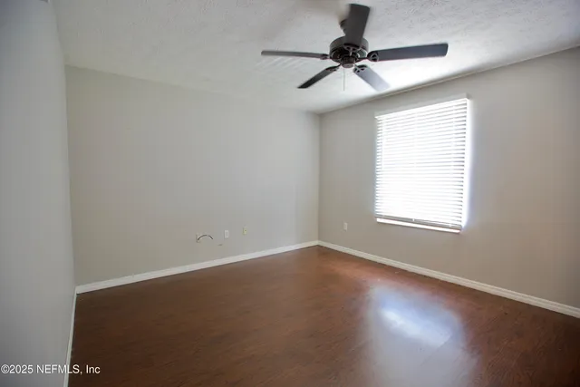 a view of room with window and a ceiling fan