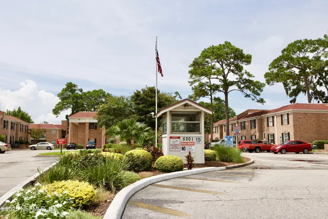 a front view of a house with a yard and potted plants