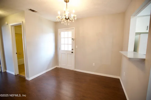 a view of livingroom with chandelier and wooden floor
