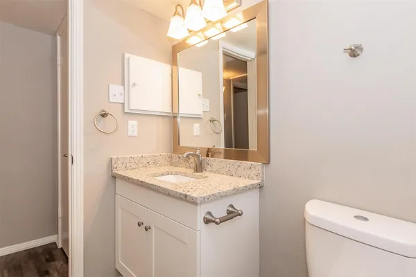 a bathroom with a granite countertop sink a toilet and shower