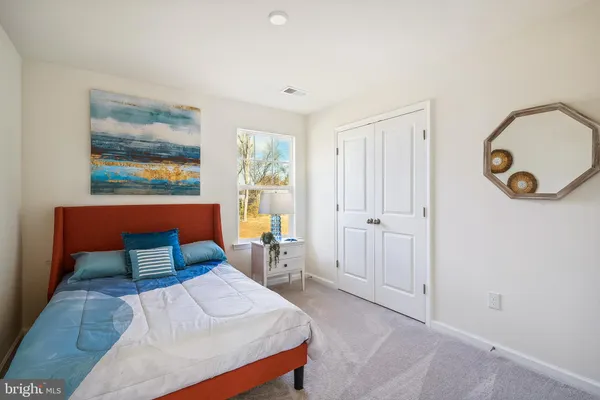 a bedroom with a bed and a painting on the wall