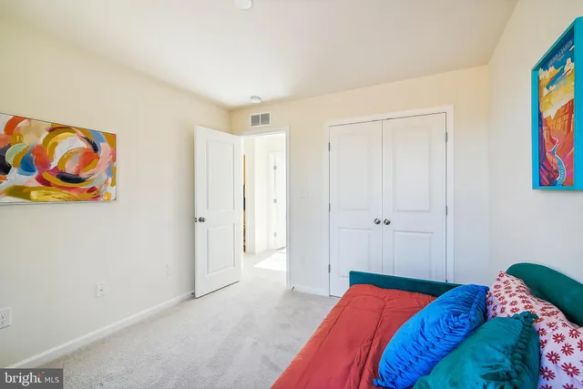 a bedroom with a bed and painting on the wall