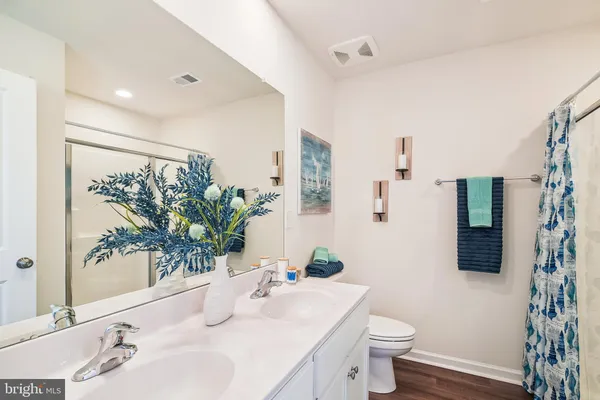 a bathroom with a sink a toilet and a large mirror