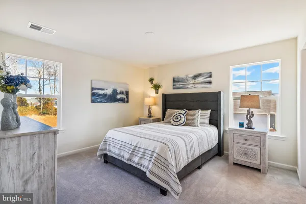 a bedroom with a bed a dresser and next to a window