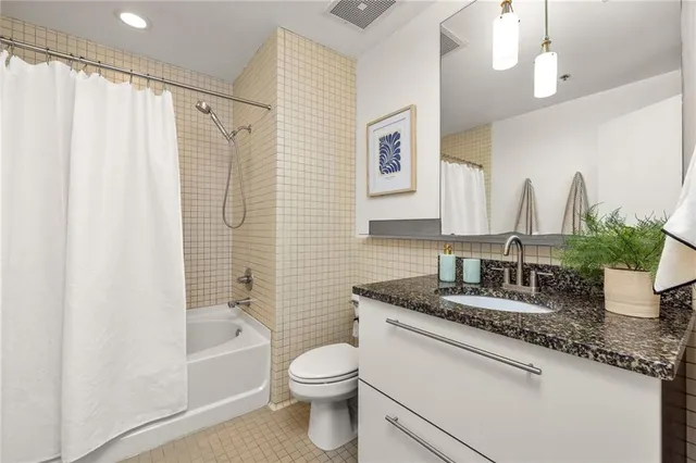 a bathroom with a granite countertop sink toilet and shower