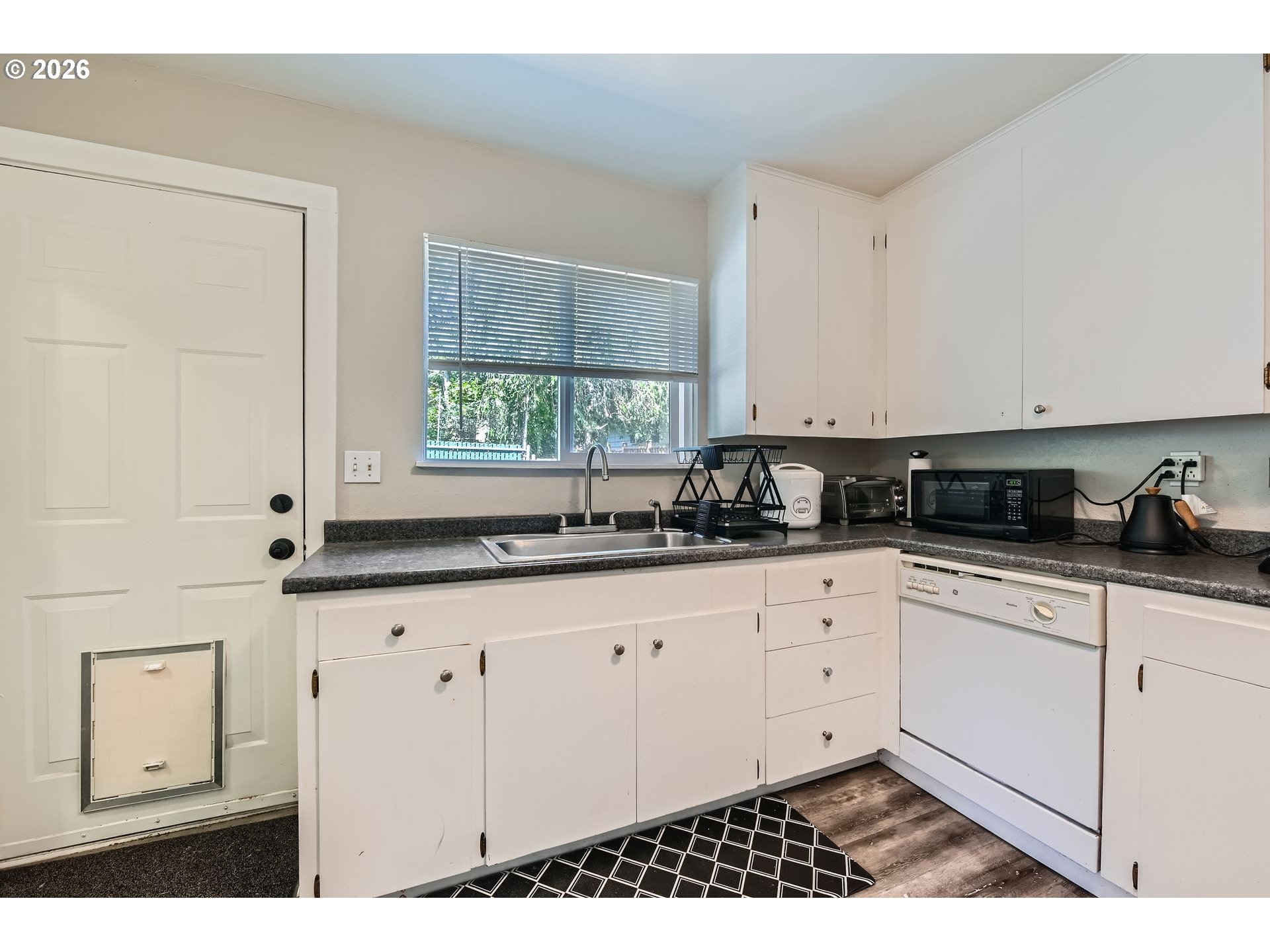 1643 Northeast 74th Avenue Portland, OR 97213 - Photo 9 of 24 a kitchen with granite countertop white cabinets and window
