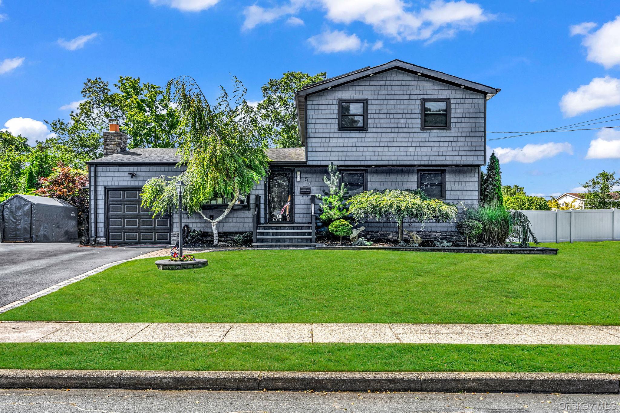 58 39th Street Islip, NY 11751 - Photo 1 of 1 a front view of a house with a yard and garage