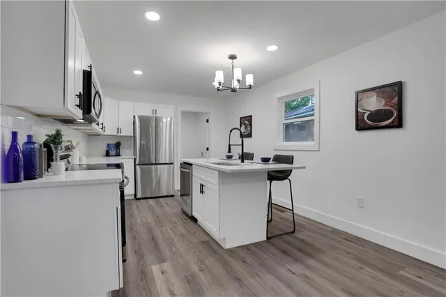 a kitchen with stainless steel appliances a sink cabinets and wooden floor