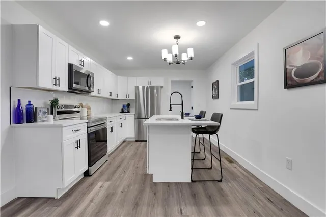 a kitchen with a sink a microwave and cabinets