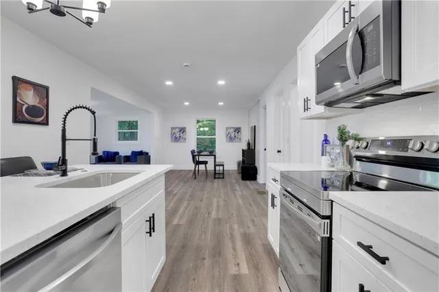 a large kitchen with stainless steel appliances granite countertop a lot of counter space and wooden floors