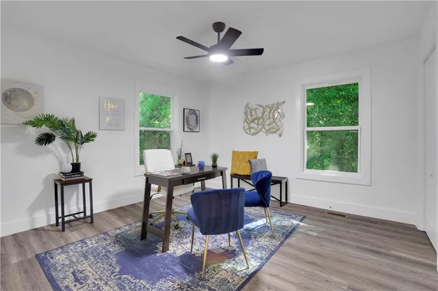 a living room with furniture a window and a potted plant