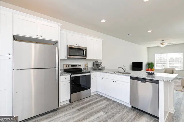 a kitchen with stainless steel appliances a refrigerator stove microwave and sink