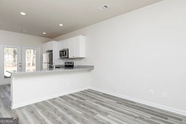 a view of kitchen with granite countertop cabinets and sink