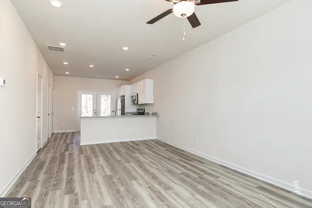 a view of empty room with wooden floor