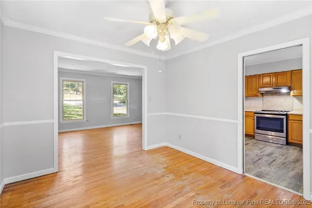 a view of an empty room with window and wooden floor