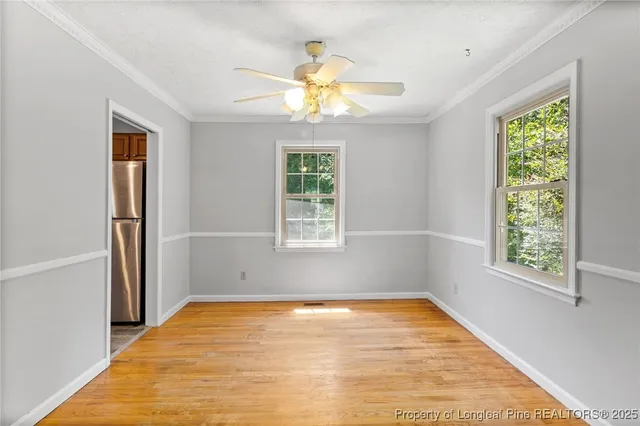 a view of empty room with window and ceiling fan