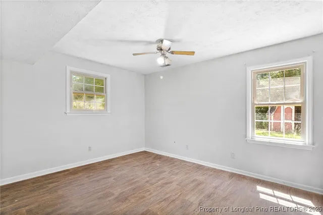 a view of an empty room with wooden floor