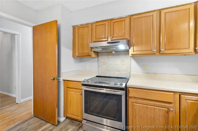a kitchen with granite countertop cabinets stainless steel appliances and a counter space