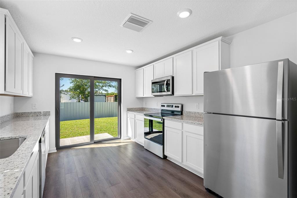 11308 Linnet Road Weeki Wachee, FL 34614 - Photo 5 of 8 a kitchen with stainless steel appliances a refrigerator sink and microwave