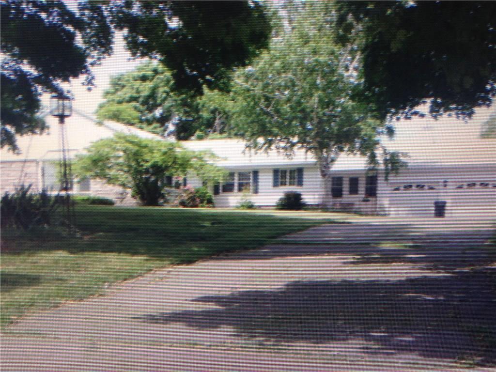 a front view of a house with a yard and trees