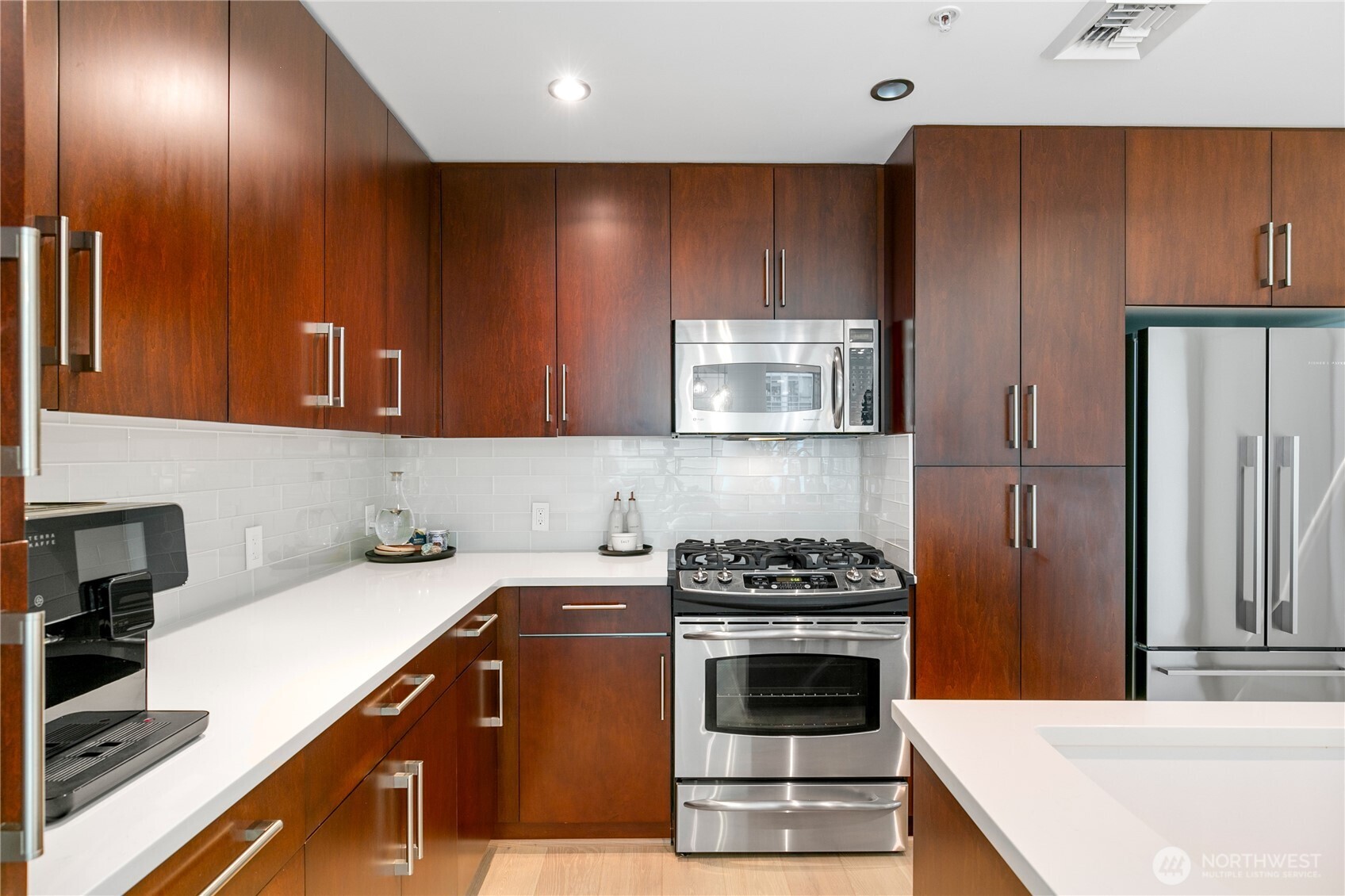 910 Lenora Street, Unit S1009 Seattle, WA 98121 - Photo 11 of 35 a kitchen with stainless steel appliances wooden cabinets and a stove top oven