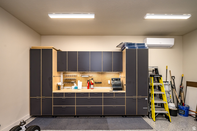 1283 North Gallen Road Santa Clara, UT 84765 - Photo 86 of 103 Detached garage workshop area with light countertops, a mini split for heating / cooling, and light speckled epoxy floor