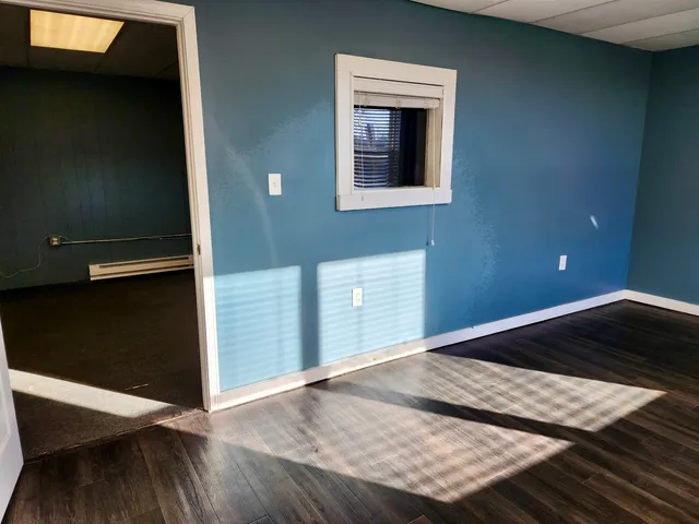 a kitchen with a wooden floor and a window
