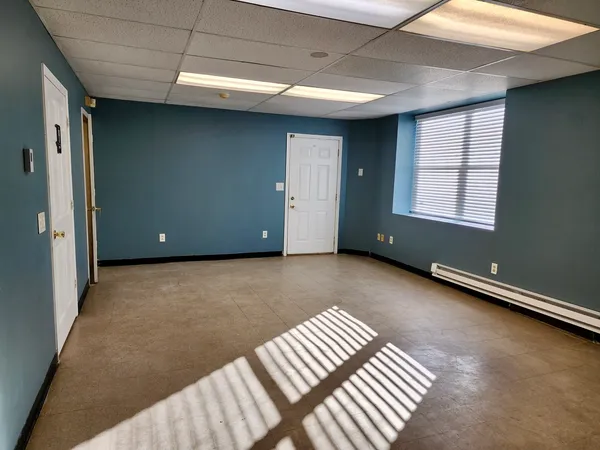 a view of an empty room with wooden floor and stairs