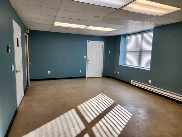 a view of an empty room with wooden floor and stairs