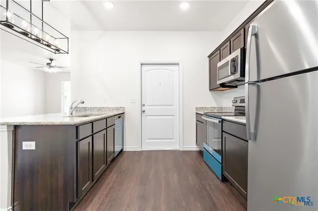 a kitchen with cabinets and stainless steel appliances