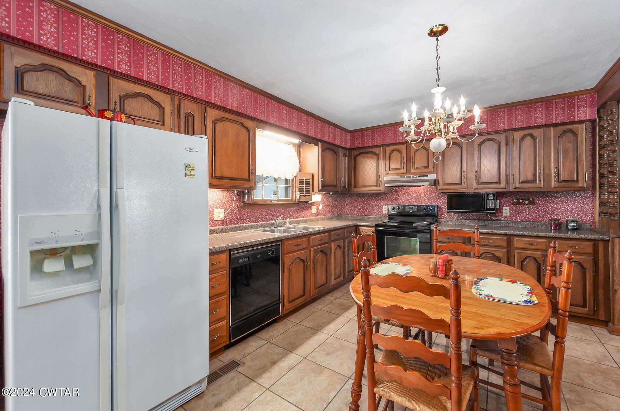 101 Hadley Drive Rutherford, TN 38369 - Photo 5 of 25 a kitchen with stainless steel appliances granite countertop a refrigerator a sink dishwasher a stove and a dining table with wooden floor