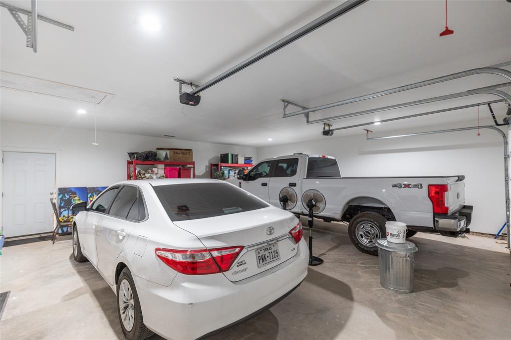760 Wimberly Road Merkel, TX 79536 - Photo 32 of 35 Attached two-car garage featuring a concrete floor, bright overhead lighting, and two automatic garage door openers