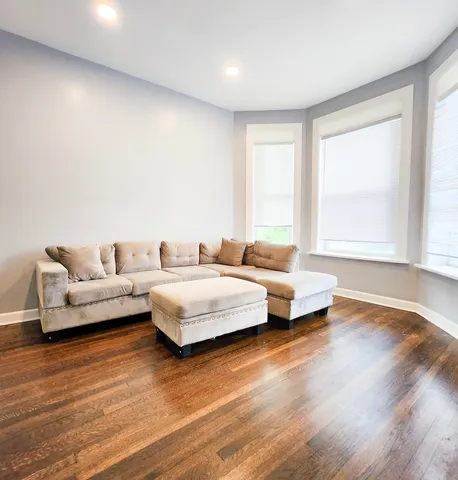 a spacious bedroom with a bed and wooden floor