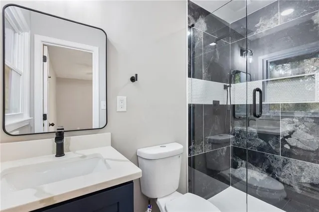 a bathroom with a sink a toilet and shower