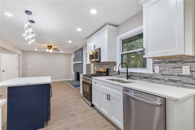 a kitchen with a sink dishwasher a stove and a refrigerator with wooden floor