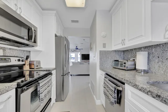a bathroom with a granite countertop sink a toilet and a shower