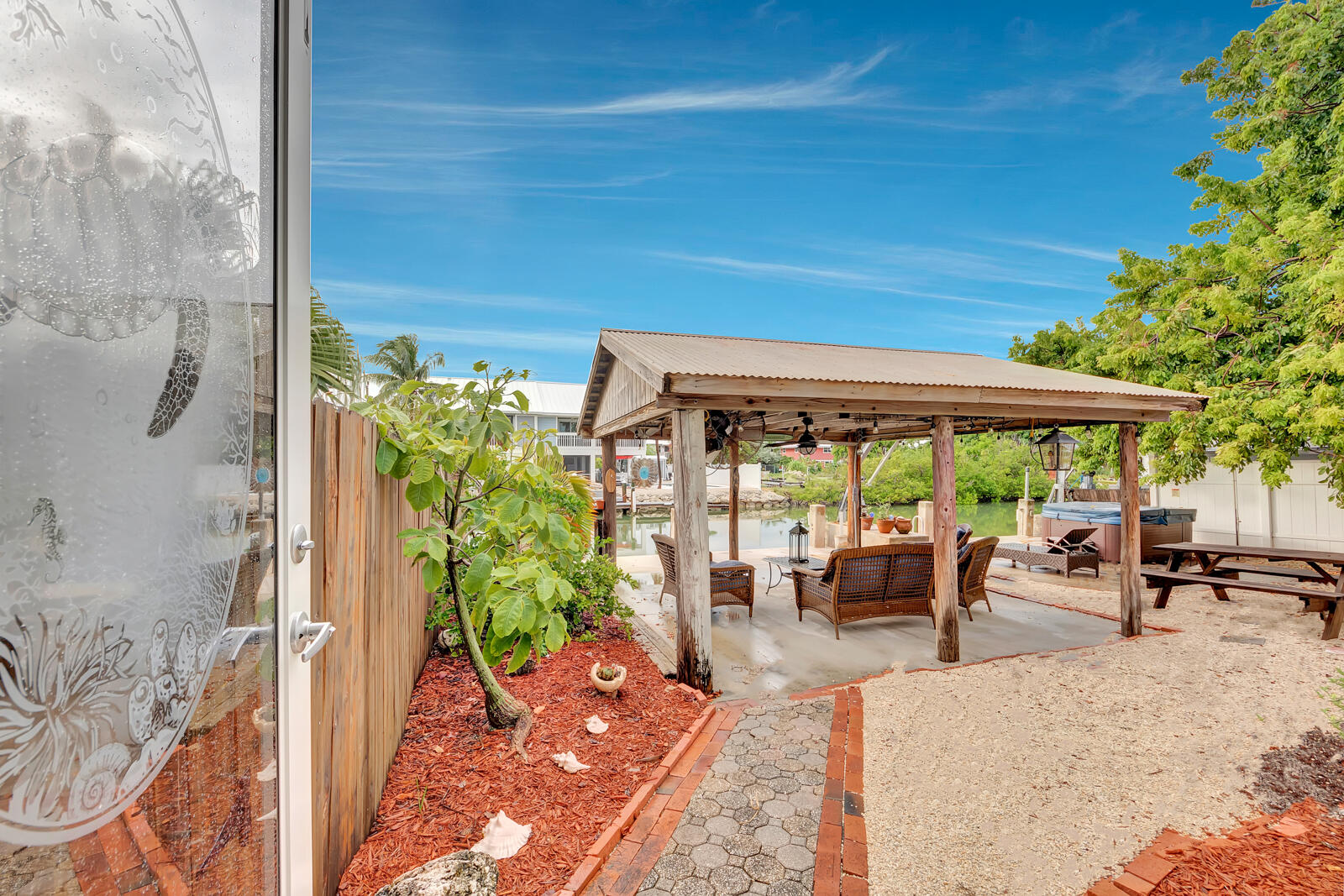 308 Sombrero Beach Road, Unit 1 & 3 Marathon, FL 33050 - Photo 36 of 36 a view of a patio with table and chairs potted plants with wooden floor and fence