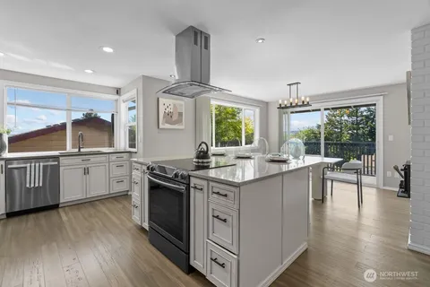 a kitchen with white cabinets and wooden floor