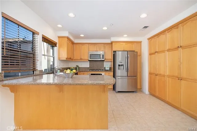 a large kitchen with a large window a refrigerator and a sink