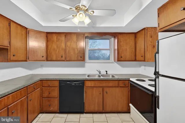 a kitchen with a sink a stove cabinets and a window
