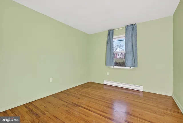 an empty room with wooden floor and window