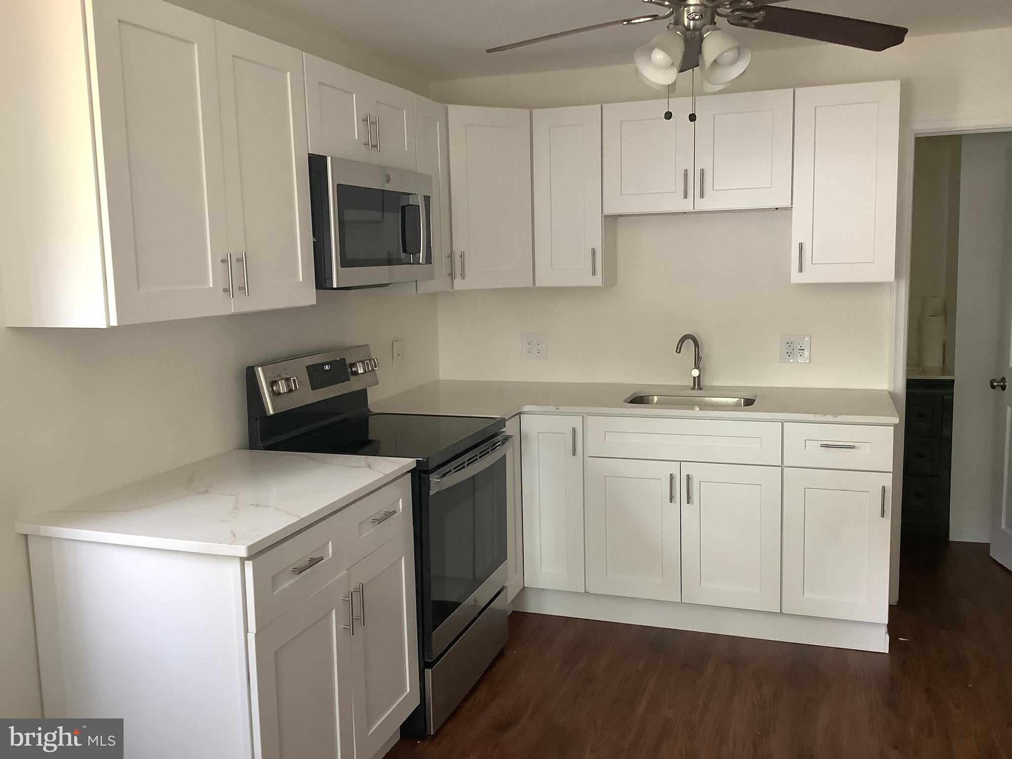 21 Davis Avenue Clementon, NJ 08021 - Photo 7 of 15 a kitchen with white cabinets sink and stainless steel appliances