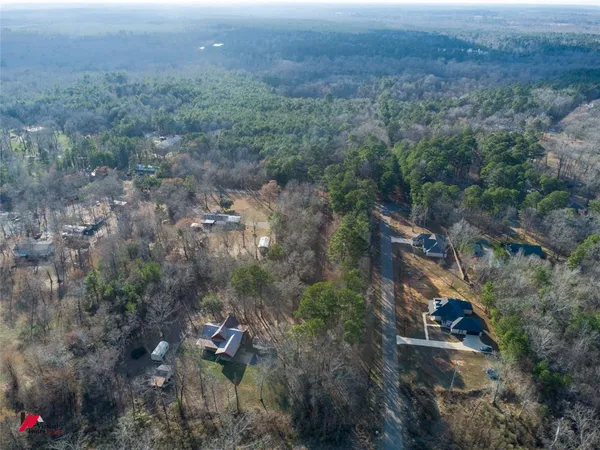 an aerial view of residential house and trees all around