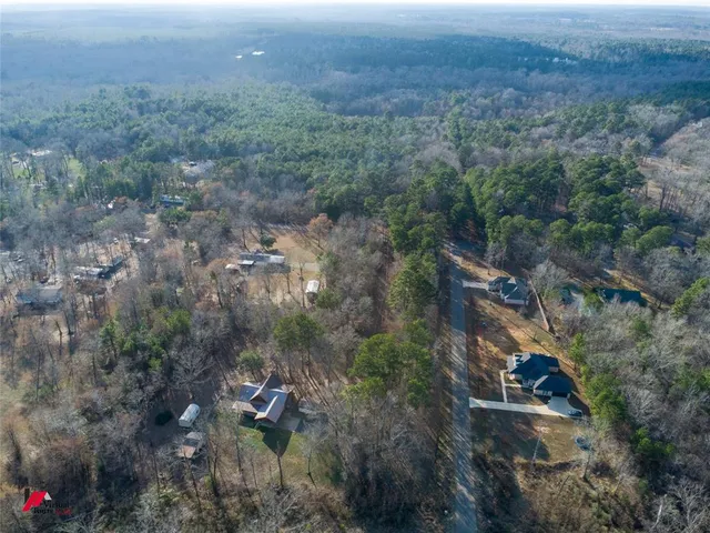 an aerial view of residential house and trees all around