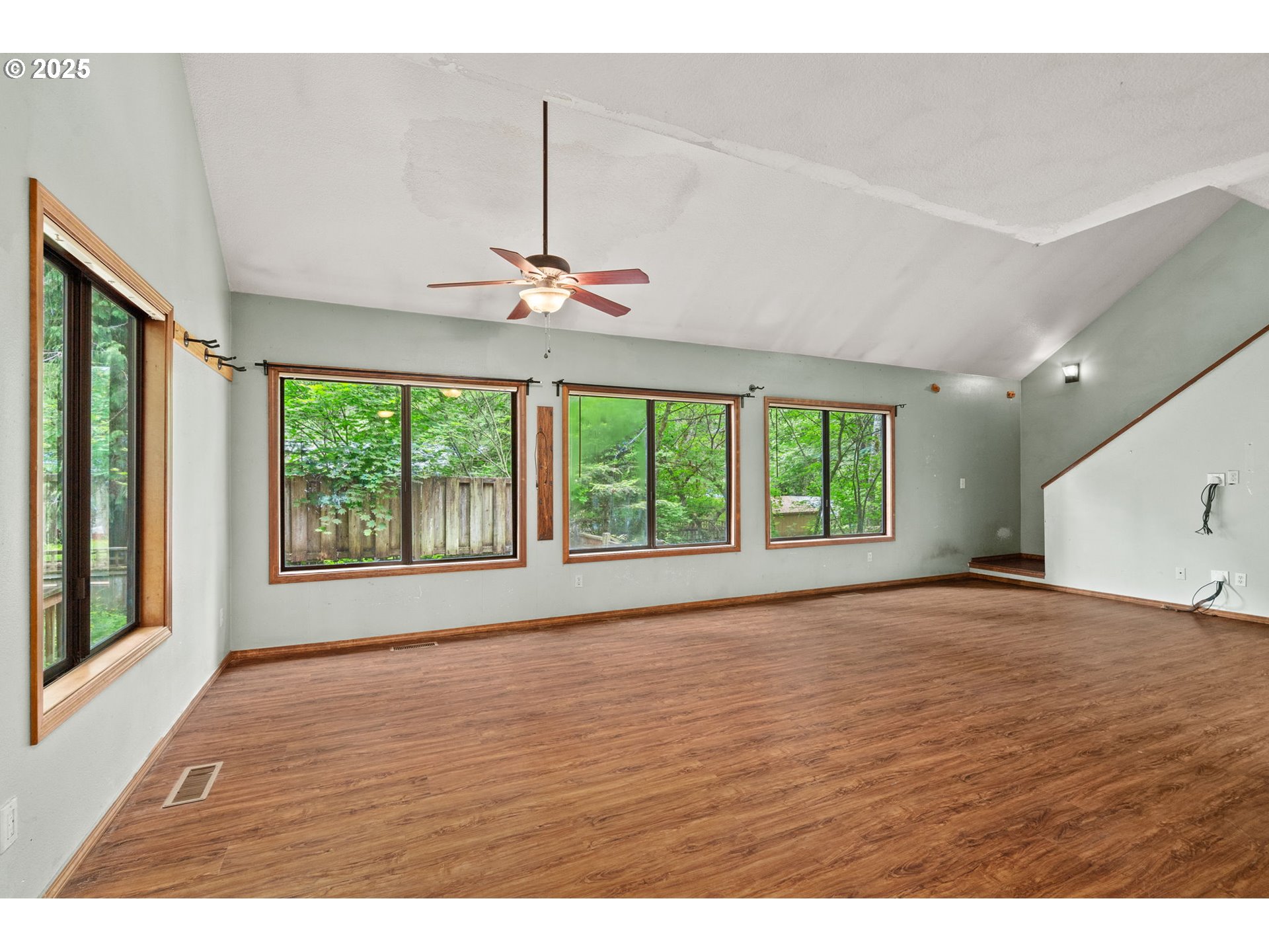 64950 East Pine Tree Way Rhododendron, OR 97049 - Photo 5 of 25 a view of an empty room with wooden floor fridge and a window