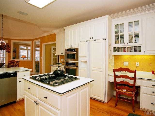 500 Wild Rose Court Raleigh, NC 27615 - Photo 6 of 12 a kitchen with a stove a refrigerator and wooden floor