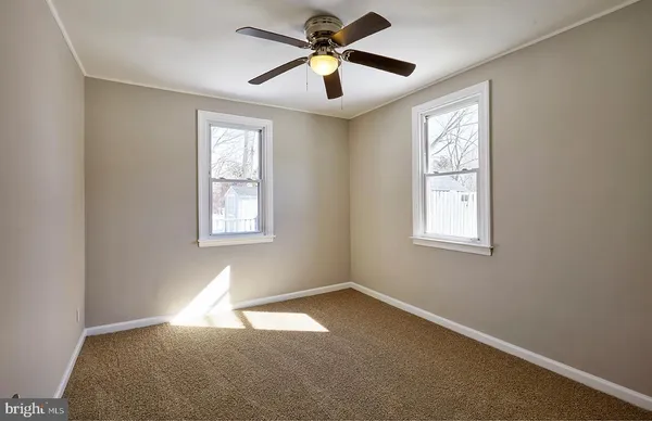 a view of a room with windows and chandelier fan