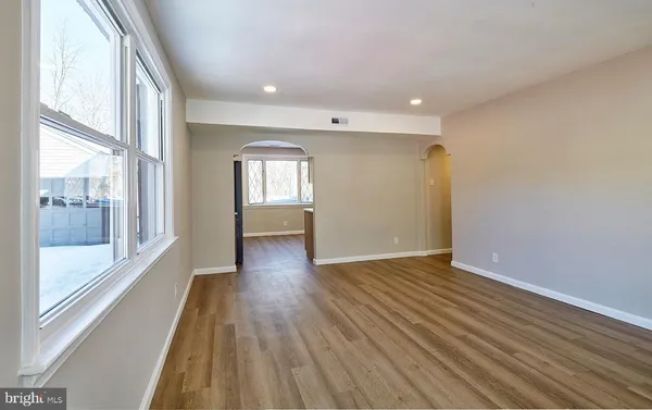 a view of wooden floor in an empty room with a window